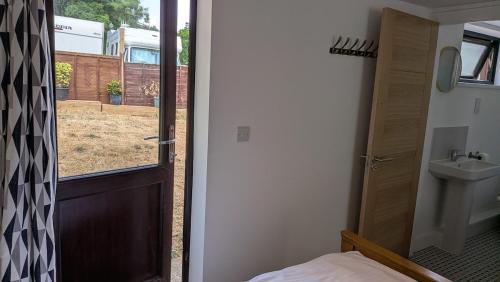 a door to a bathroom with a sink and a toilet at The Annexe in West Buckland