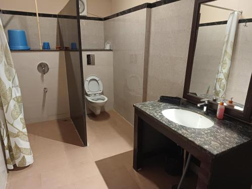 a bathroom with a sink and a toilet at Shivir Aranya - Wilderness Resort Sariska in Alwar