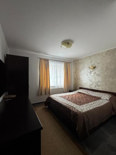 a bedroom with a bed and a window at Casa David in Rădăuţi