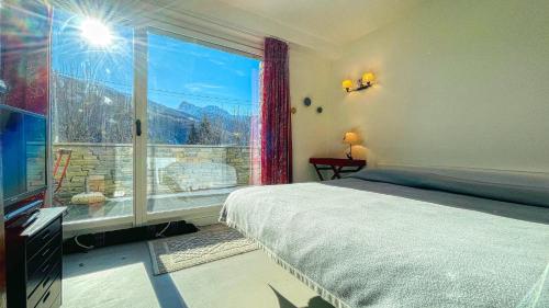 a bedroom with a bed and a large window at La Sequoia - Maison dOc in Bardonecchia