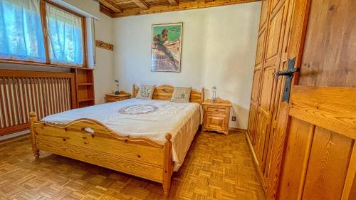 a bedroom with a wooden bed and a wooden door at Eugenia - Maison dOc in Bardonecchia