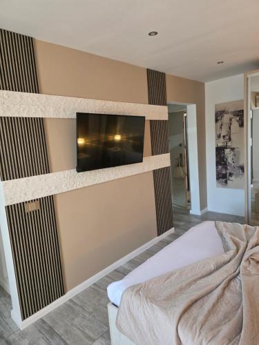 a bedroom with a flat screen tv on the wall at Smart Apartament in Brăila