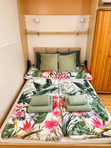 a bed in a room with a floral bedspread at Cozy Studio in Szentendre