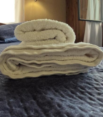 a pile of towels sitting on top of a bed at Altos de Soberana in El Calafate