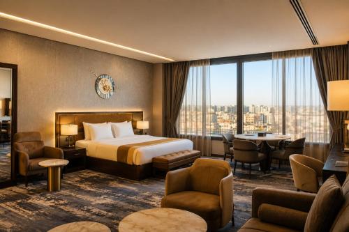 a hotel room with a bed and a table and chairs at Leaf Suites - أجنحة ليف in Ar Rass