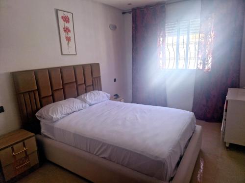 a bedroom with a large white bed with a window at la Casa de doha in Tangier