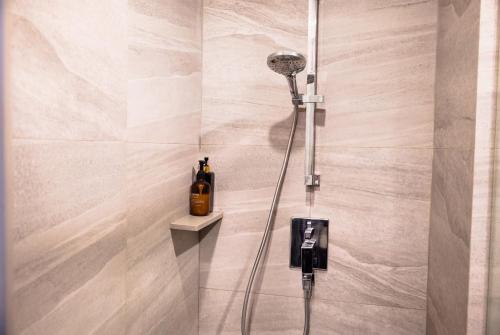 a shower with a shower head in a bathroom at EDGE Central Pattaya 2BR Ocean View Luxury Condo Rooftop Pool Central Location in Pattaya