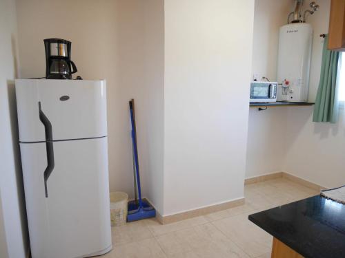 a kitchen with a white refrigerator in a room at Ayinmai departamento C in Trelew