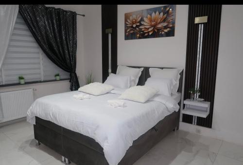 a bedroom with a large bed with white sheets and pillows at JBM Appartement spéciaux Gare de Vilvorde - Bruxelles Airport &Brussel Expo in Vilvoorde