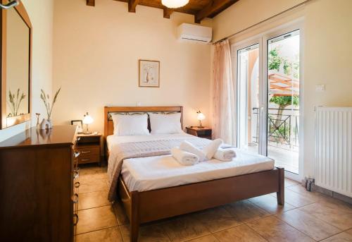 a bedroom with a bed and a desk and a window at Agapi's House in Kanali