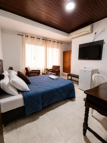 a bedroom with a bed and a flat screen tv at Hotel Arauca Colonial in Arauca