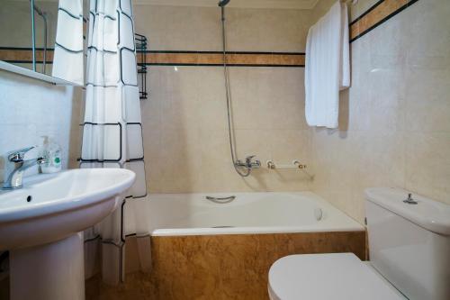 a bathroom with a sink and a toilet and a bath tub at Agapi's House in Kanali