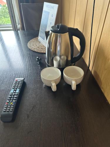 a tea kettle on a table next to a remote control at Green House in Karakol
