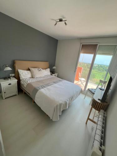 a bedroom with a bed and a large window at Condo with golf course views, pool and terraces in San Jorge