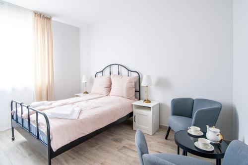 a bedroom with a bed and a chair and a table at Bieślin 41 in Bieślin