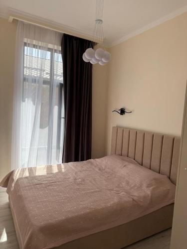 a bedroom with a bed and a window at Alpha White Resort in Koshkolʼ