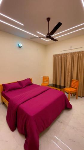 a bedroom with a large pink bed with two chairs at Seabreeze Village Resort and Restaurant in Gokarn