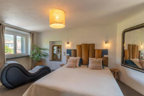 a bedroom with a large bed and a mirror at Duplex Terrasse Jacuzzi Privatif & Vue Cévennes in Saint-Jean-du-Gard
