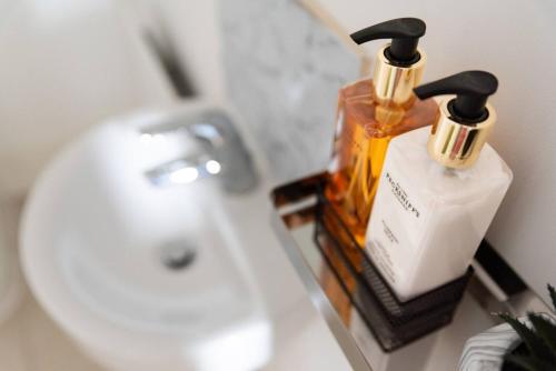 a bathroom with two bottles of soap and a sink at Convenient & cosy 3 bed house in Newport
