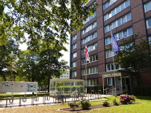 un edificio con dos banderas delante en Gästehaus Rostock Lütten Klein, en Rostock