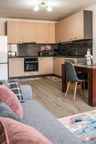 a living room with a table and a kitchen at Tryavna Central Apartments-Harmony in Tryavna