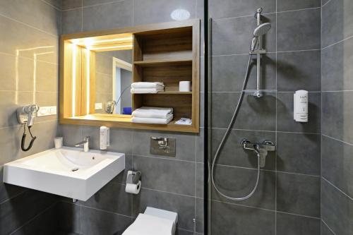 uma casa de banho com um chuveiro, um lavatório e um WC. em Hotel Centrum em Bolesławiec