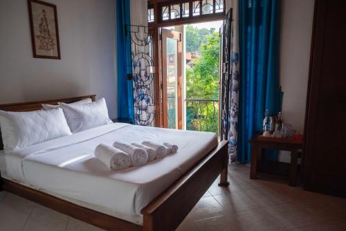 a bedroom with a bed with rolled towels on it at Eco Serenity Kandy in Kandy