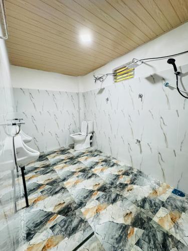 a bathroom with two toilets and a tiled floor at Glowhaven Hostel in Sigiriya