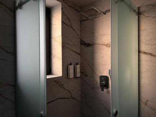 a bathroom with a shower with a glass door at ZOSANA Villa in Kallithea Halkidikis