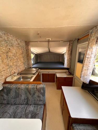 an rv with a kitchen and a sink in it at Privet creek side glamping in Chase