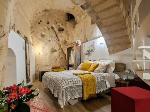 a bedroom with a bed and a stone wall at Il Geco in Matera