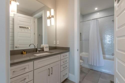a white bathroom with a sink and a shower at Spacious Gulch Retreat Super Skyline Views in Nashville