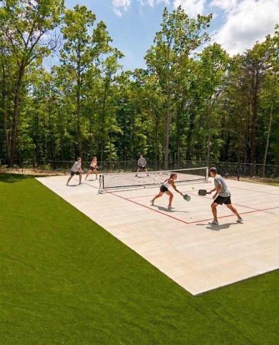 a group of people playing tennis on a tennis court at Pristine, Quaint Tiny Home! The Hemlock Hideaway in Rising Fawn