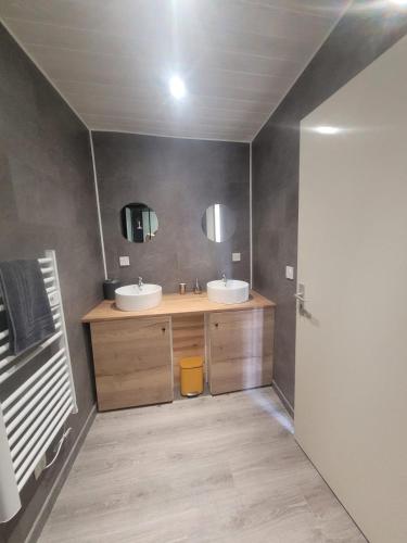 a bathroom with two sinks and two mirrors at Duplex des Volcans in Montaigut-le-Blanc
