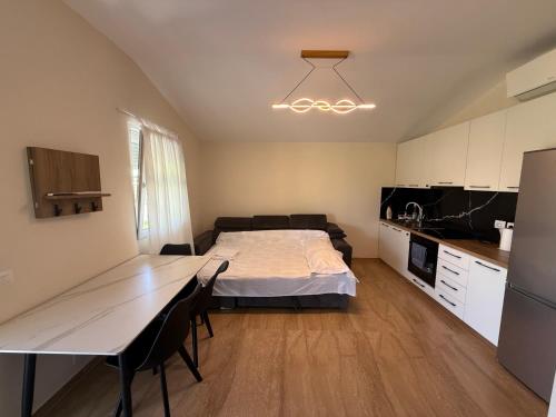 a room with a bed and a table and a kitchen at Garden beach house in Hamallë