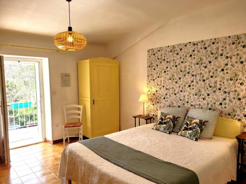 a bedroom with a large bed and a yellow cabinet at Le Mas Cauvy in Saint-Christol-lès-Alès