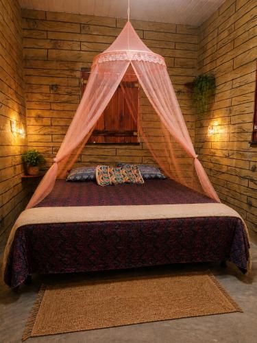 a bedroom with a bed with a net on it at Abrigo de Montanha Quixadá in Quixadá