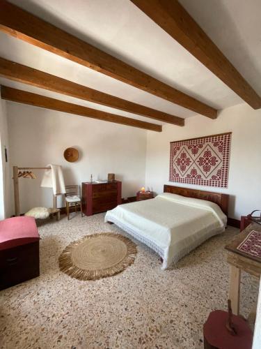 a bedroom with a large bed and a table at Nuragic Temple in Esterzili