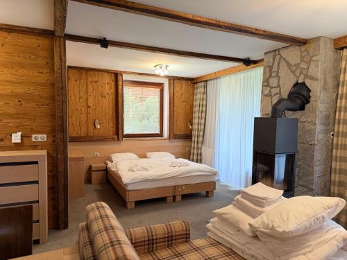 a hotel room with two beds and a fireplace at Hotel Kukučka Apartment C104 Tatranská Lomnica in Vysoké Tatry