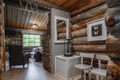a room with wooden walls and a table and chairs at Rukan Lumikelo in Kuusamo