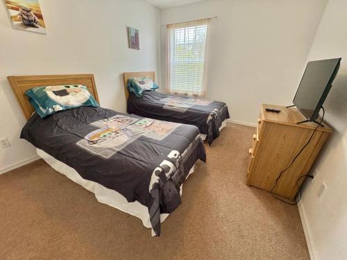 a bedroom with two beds and a flat screen tv at Villa With Private Pool, and Lake Views in Davenport