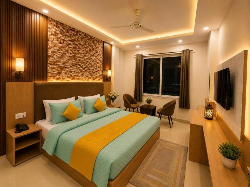 a bedroom with a large bed and a television at Palm Bliss A Luxury Hotel in Haridwār