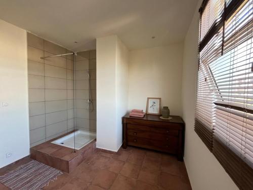 a bathroom with a shower and a wooden dresser at Grande Maison Mandrosoa in Abohijanahary