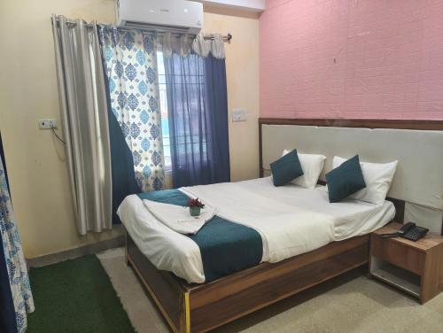 a bedroom with a bed and a window at Woohoo Hotels in Patna