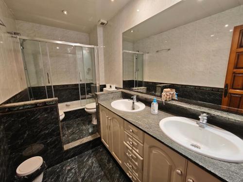 a bathroom with two sinks and a shower and a toilet at Bonamar in Cabrera de Mar