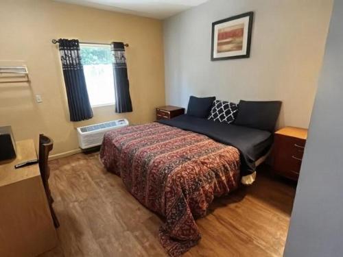 a bedroom with a bed and a window at Crown Inn in Carrollton