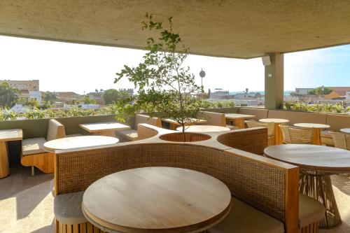 a restaurant with tables and chairs and a tree at Hotel El Balconario by Faranda Boutique in Cartagena de Indias