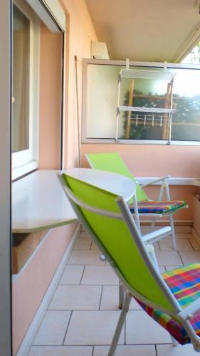 a green chair sitting in a room with a window at Beaches within walking distance private parking! in Six-Fours-les-Plages