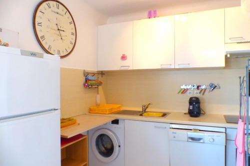a kitchen with a washing machine and a clock on the wall at Beaches within walking distance private parking! in Six-Fours-les-Plages