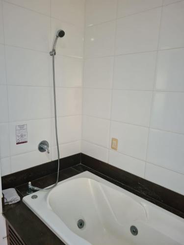 a bath tub with a shower in a bathroom at Suite Pipa Beleza Spa Resort in Pipa